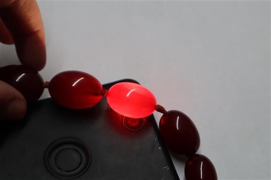 A single strand graduated simulated cherry amber necklace, gross weight, 114 grams, 82cm.